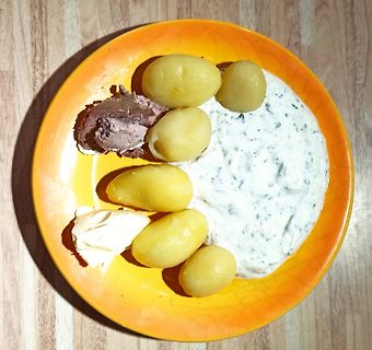 Kartoffeln mit Kräuterquark und Aufstrich auf gelbem Teller