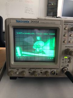 Abfotografiertes Tektronix Oszilloskop mit Cartoon-Bild auf dem Display