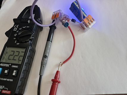 Multimeter misst Spannung an Batterie mit Klemmen