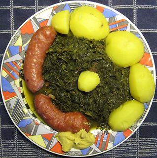 Teller mit Kartoffeln, Wurst und Spinat