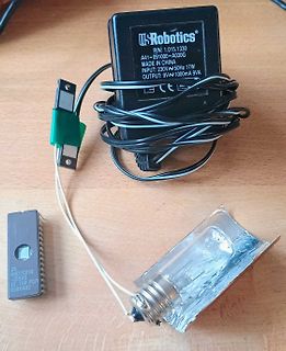Netzteil, Glühbirne und Kabel auf Holzuntergrund