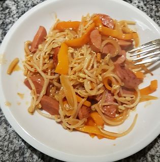 Nudeln mit Wurst und Gemüse auf weißem Teller