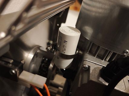 Nahaufnahme eines weißen Kondensators in einer mechanischen Vorrichtung
