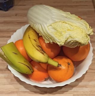 Obstschale mit Bananen, Orangen und Chinakohl