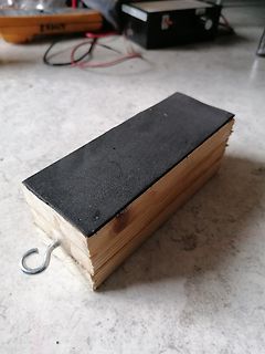 Holzblock mit schwarzer Oberseite und Haken