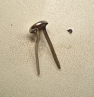 Metallischer Stift oder Clip auf hellem Untergrund
