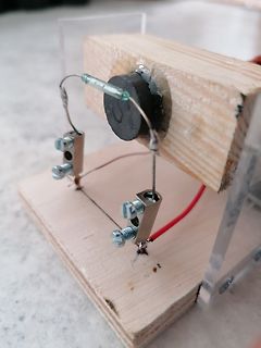 Experimenteller Aufbau mit Widerstand und Klemmen auf Holz