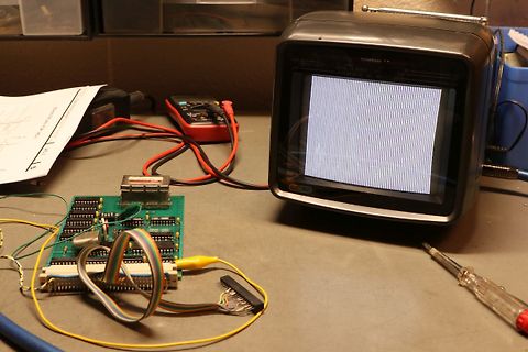 Elektronik-Versuchsaufbau mit Monitor, Multimeter und Leiterplatte