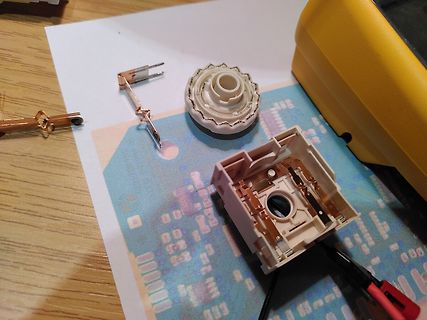 Zerlegte mechanische Teile eines Tastenschalters auf Papier
