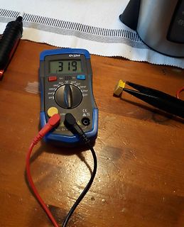 Digitalmultimeter misst Kondensator auf Holzuntergrund