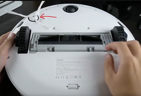 Unterseite eines Saugroboters mit rotem Pfeil