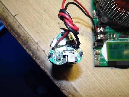 Elektronikbauteile mit Display und Kabeln auf Holzuntergrund