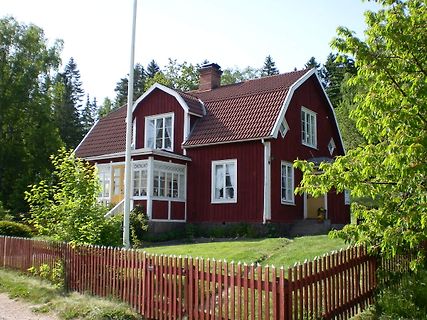 Rotes Holzhaus mit weißem Zaun