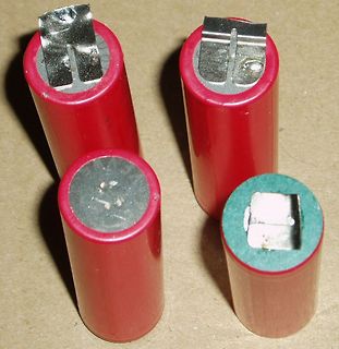 Vier rote Elektrolytkondensatoren mit abgebogenen Metallstreifen