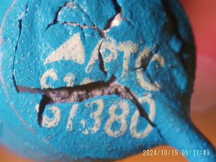 Nahaufnahme eines beschädigten blauen Bauteils mit Aufschrift