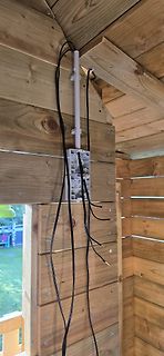 Elektrische Installation in Holzhütte mit Kabeln und Steckdosenrahmen