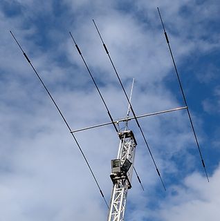 Antenne auf einem Gittermast vor blauem Himmel