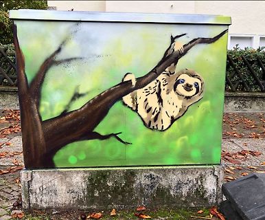 Graffiti eines Faultiers auf einem Metallkasten