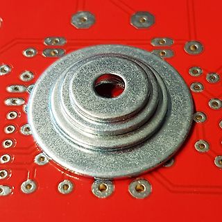 Metallischer Druckknopf auf roter Leiterplatte