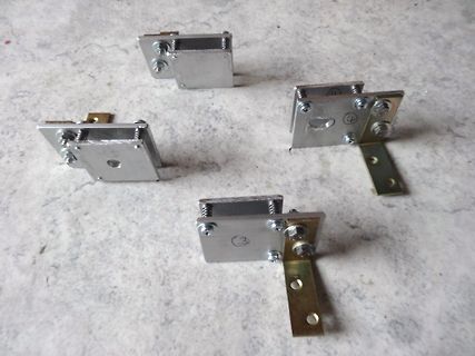 Vier metallische Bauteile oder Halterungen