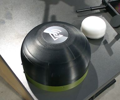 Schwarzes Gehäuse mit Logo und weißem runden Objekt