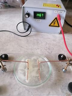 Versuchsaufbau mit Netzgerät und Elektrolyse in Petrischale