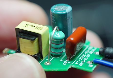 Nahaufnahme einer bestückten Leiterplatte mit elektronischen Bauteilen