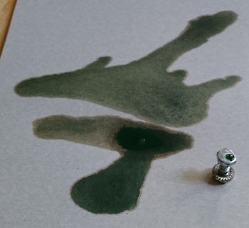 Grüne Flüssigkeit auf Papier mit Schraube