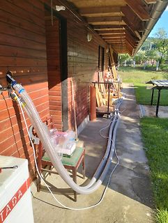 Schlauchleitung vor einem Holzgebäude