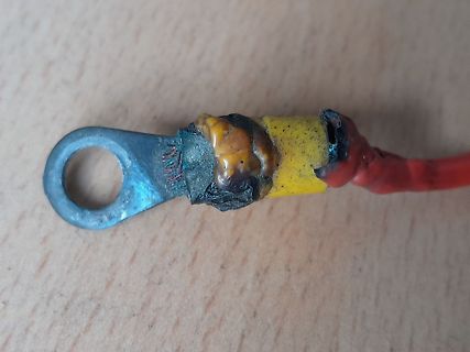 Geschmolzener Kabelschuh an rotem Kabel