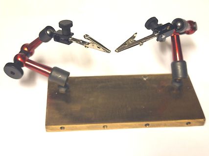 Zwei mechanische Greifarme auf einer Holzplatte