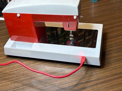 Mini-Nähmaschine mit rotem Netzkabel