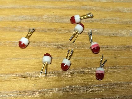 Mehrere rote Elektrolytkondensatoren auf Holzuntergrund