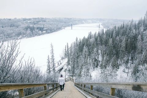 Person auf Holzsteg in verschneiter Landschaft