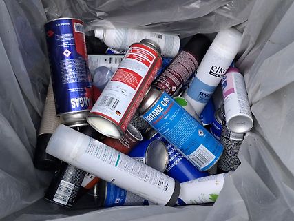 Sprühdosen in einem Müllbeutel