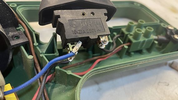 Innenansicht eines geöffneten Elektrogeräts mit Anschlussklemmen
