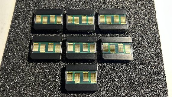 Sie sieben kleine elektronische Bauteile auf schwarzem Untergrund