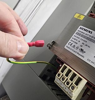 Hand hält Kabel an Siemens Transformator
