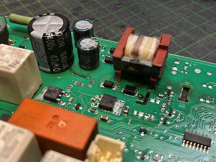 Nahaufnahme einer bestückten Leiterplatte mit Elektrolytkondensatoren und Transformator