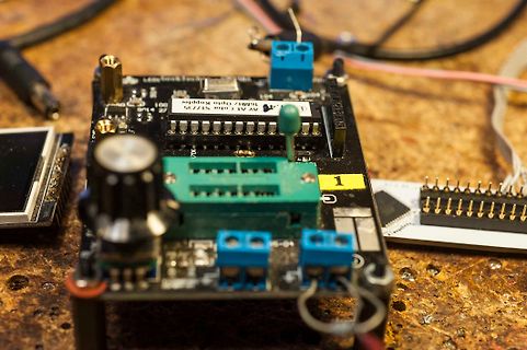 Elektronik-Aufbau mit Leiterplatte und Bauteilen auf Werkstattuntergrund