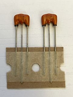 Zwei orangefarbene Bauteile auf Kartonstück
