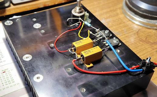 Elektronischer Aufbau mit Kondensatoren und Kabeln auf schwarzem Untergrund