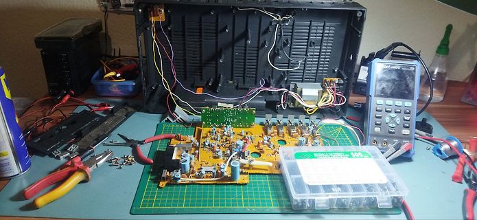 Werkstatt mit geöffnetem Gerät, Leiterplatte und Multimeter