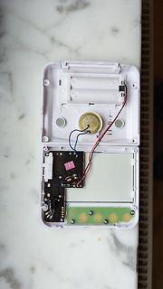 Geöffnetes elektronisches Gerät mit Platine und Batteriefach