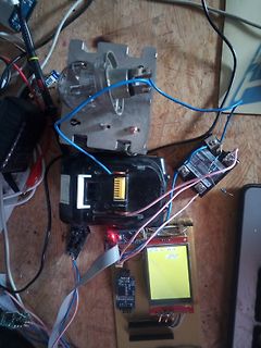 Elektronik-Aufbau mit Display und Glühbirne auf Holzbrett