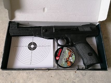 Pistole in einer Schachtel mit Zielscheibe