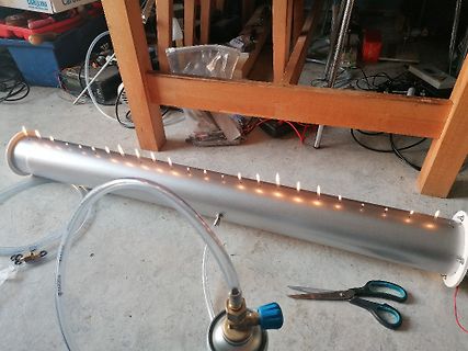 Metallrohr mit brennenden Flammen und Schlauchanschluss