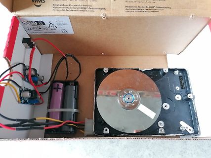 Bastelprojekt mit Festplatte, Batterien und Elektronik in Karton