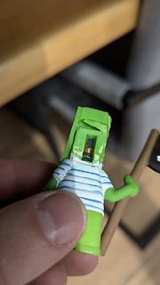 Figur mit gestreiftem Shirt und Stab