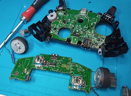 Zerlegte Elektronikplatine mit Gehäuseteilen und Werkzeug